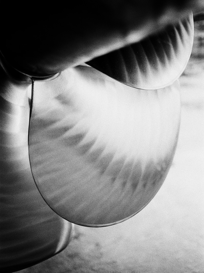 Black and white close-up of a yacht propeller blade with visible curved textures.