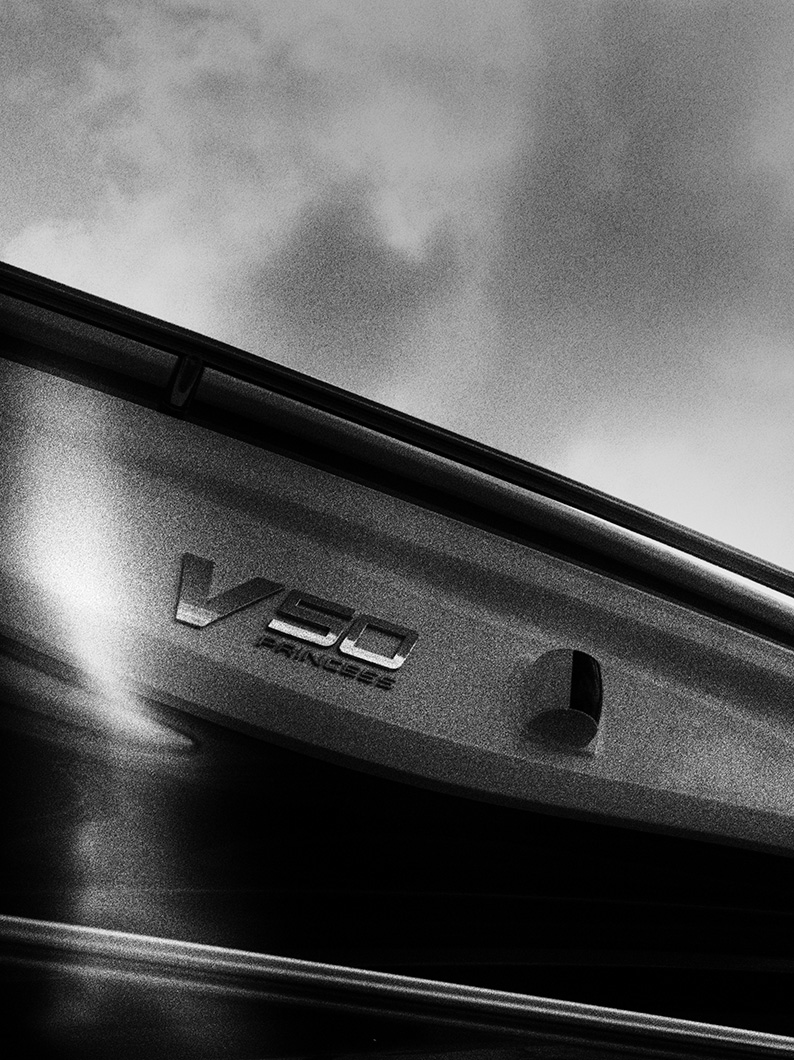 Black and white angled view of the Princess V50 yacht nameplate against a cloudy sky.