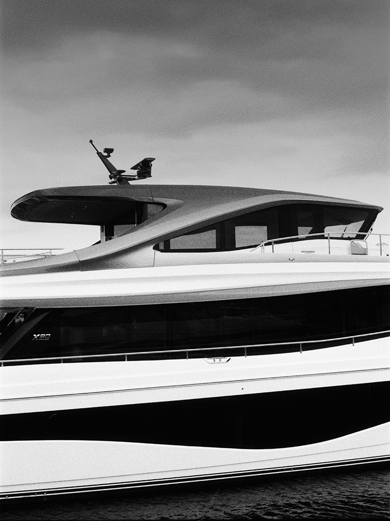 Black and white side view of a Princess yacht with sleek windows and a modern flybridge against a cloudy sky.