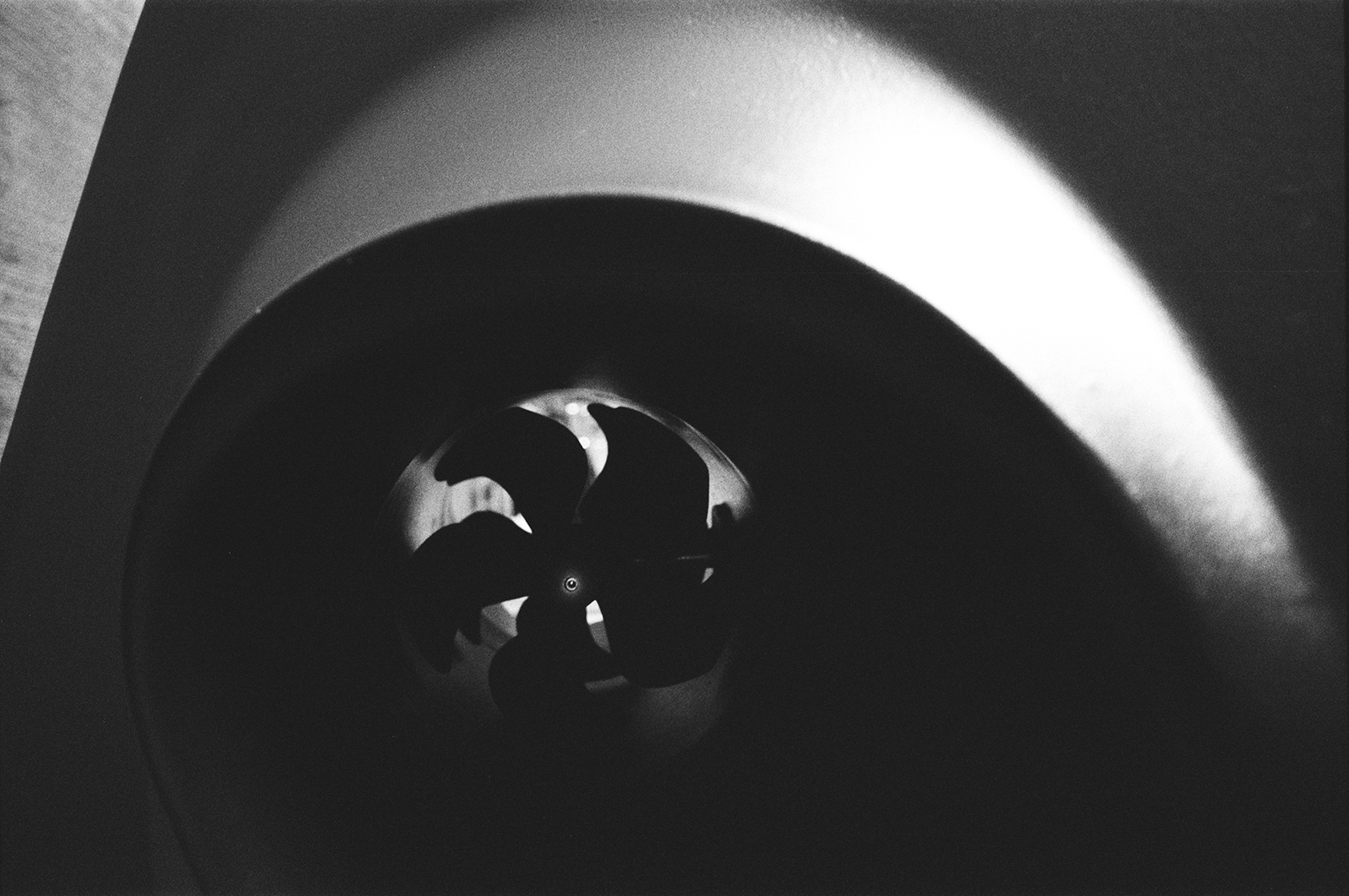 Black and white close-up of a yacht’s bow thruster tunnel showing the propeller inside.