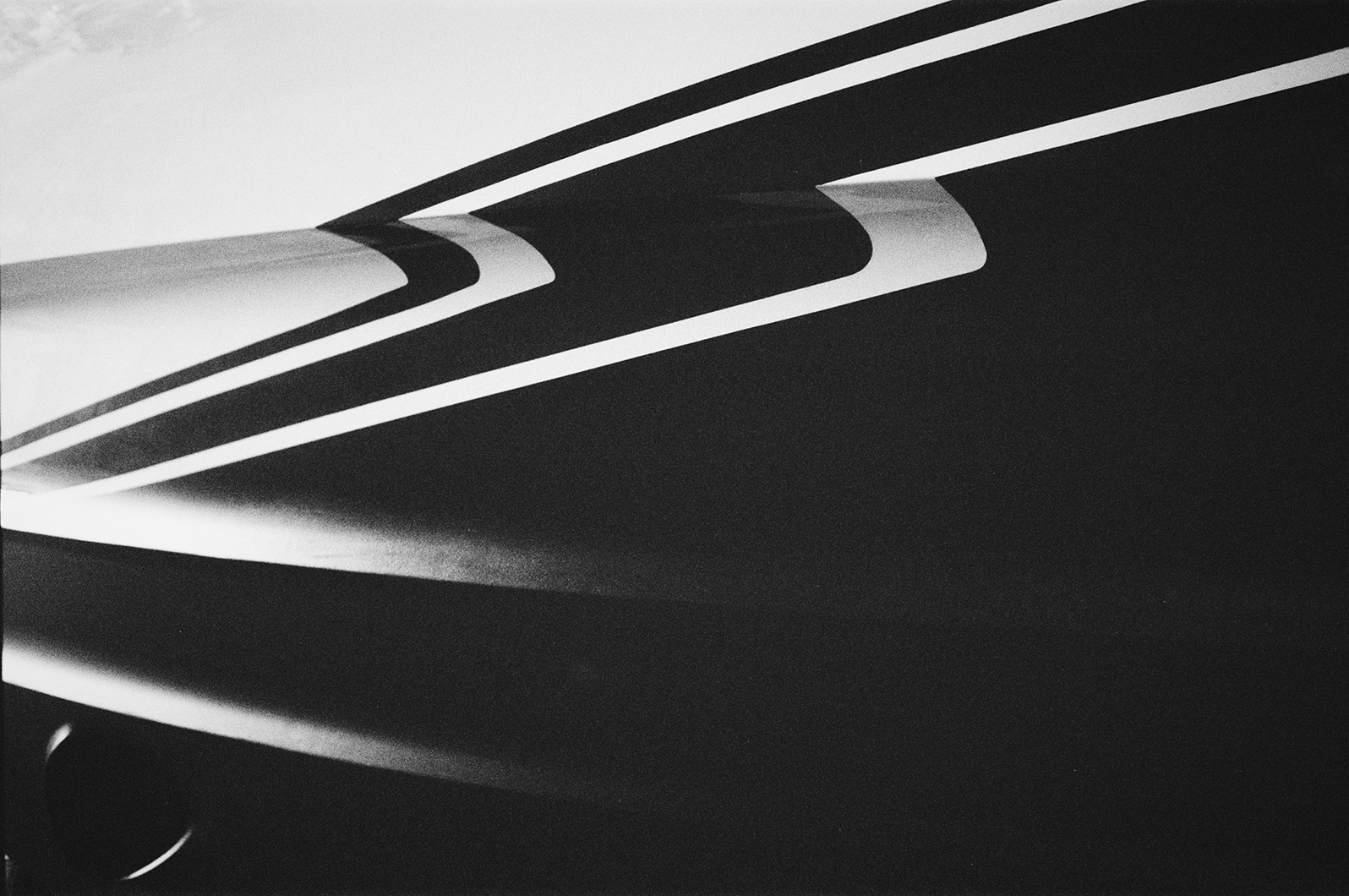 Black and white close-up of a yacht hull with bold diagonal stripe graphics.