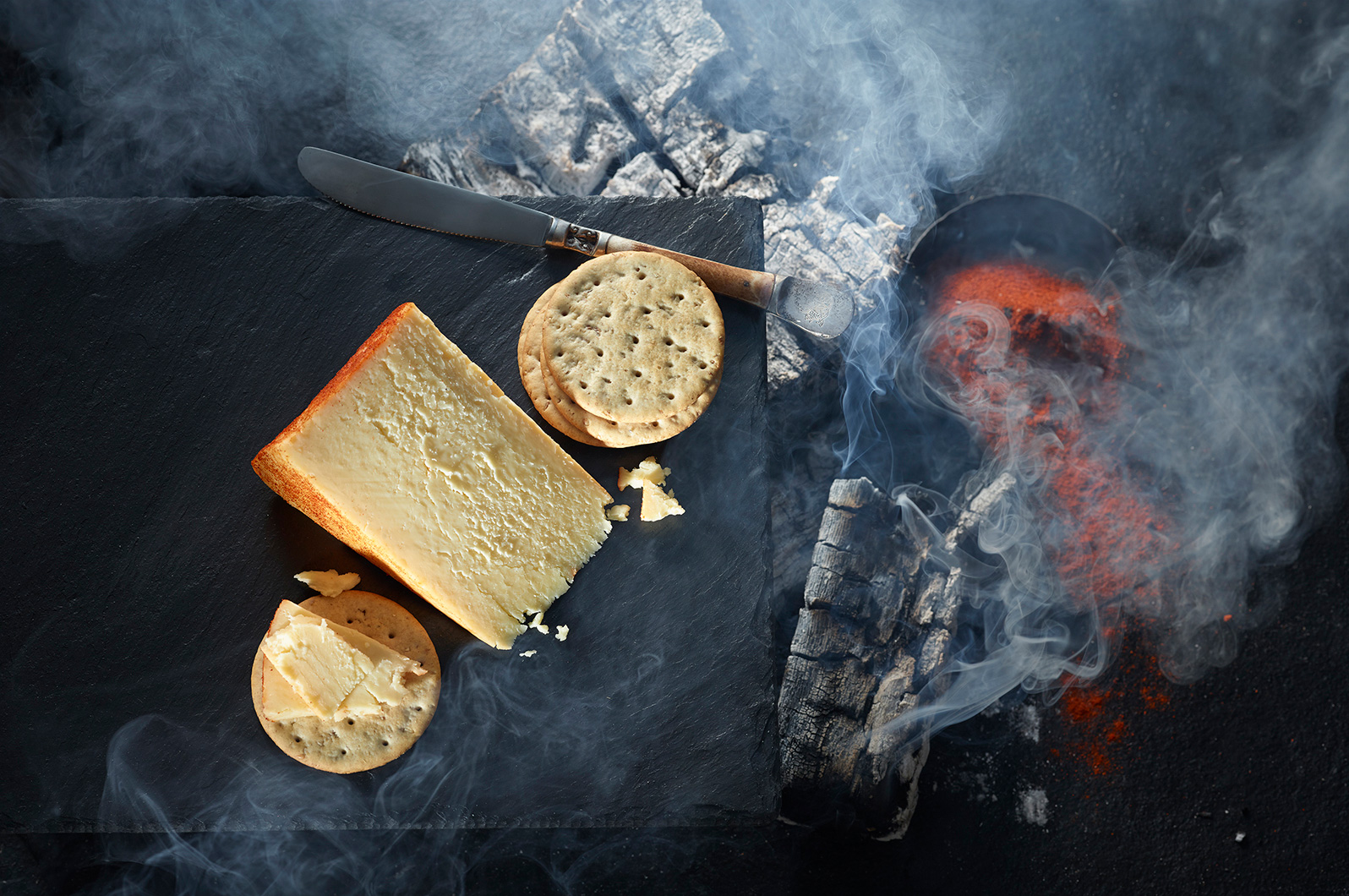 Studio images shot using burning logs to create the smoke to convey the smoked nature of the cheese.